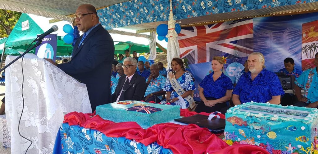 Forestry Minister Naiqamu formally introducing the project at the October 10th, 2020 event. A.D.E. Project co-directors Deb and Walter Smith are seated behind the minister (both in vibrant blue attire).