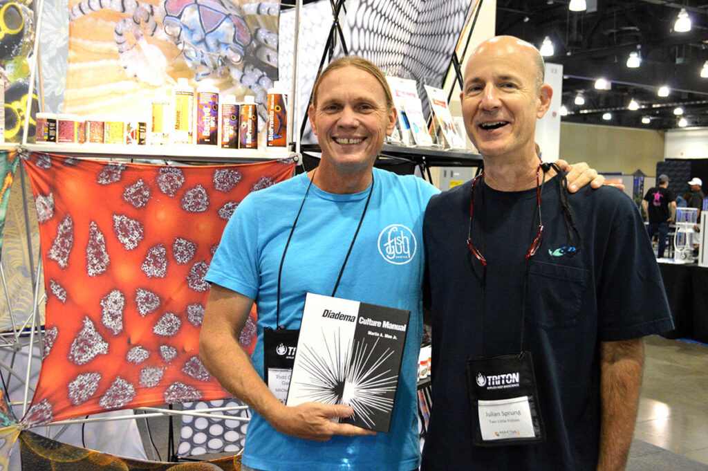 Marine fish breeder Todd Gardner poses with Julian Sprung, excited to be among the first to receive Martin A. Moe, Jr.'s newest publication, the Diadema Culture Manual.