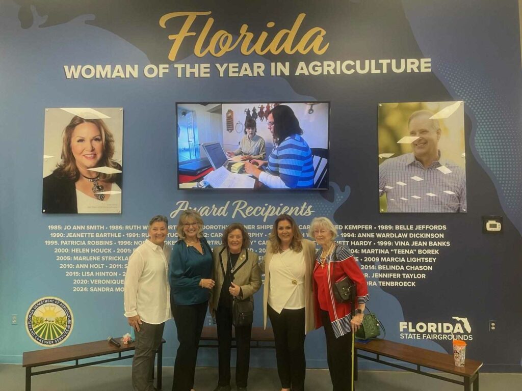 Moore and colleagues stand in front of a massive wall that honors all the Women of the Year in Agriculture Award Recipients. Image credit: Carlos Aponte.